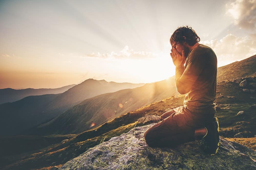 homme en éveil spirituel grâce à la méditation en montagne